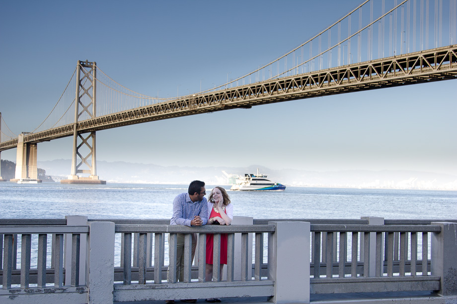 The happy couple right after he proposed with San Francisco Bay Bridge and a yacht in the background