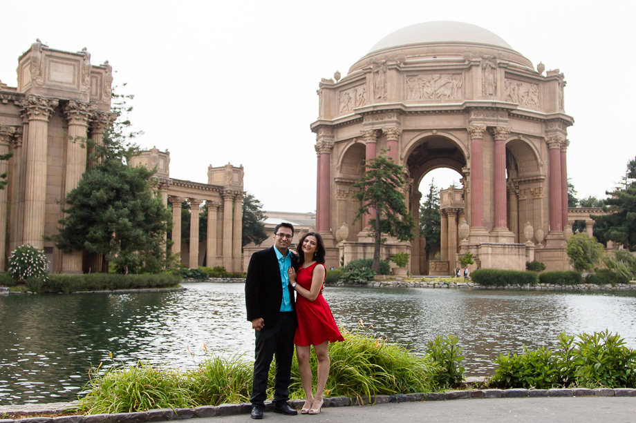 The happy couple standing in front of the pool at the Palace of Fine Arts in San Francisco