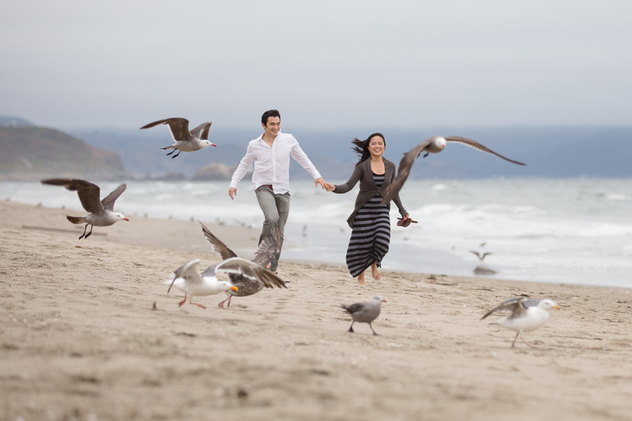 running and chasing birds on Thornton Beach near the Pacific Ocean during engagement shoot