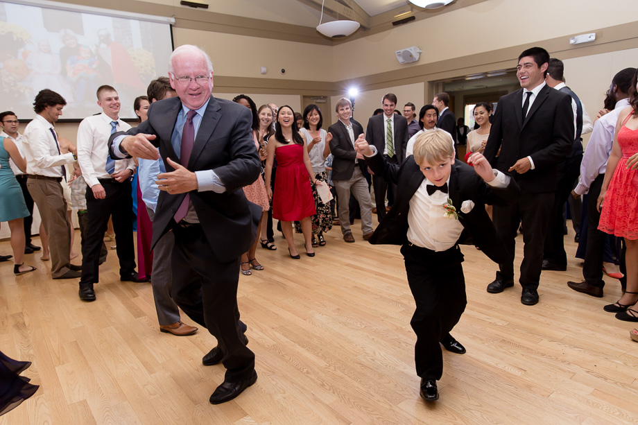 young and old wedding guests dancing at the indoor reception at night at Ladera Oaks