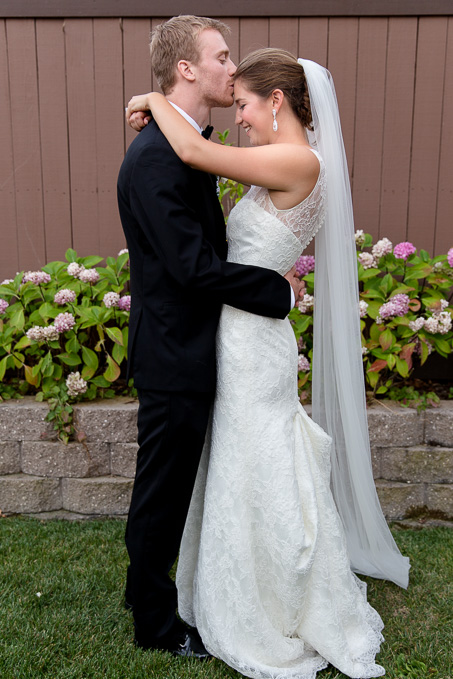 Groom kissing brides forehead