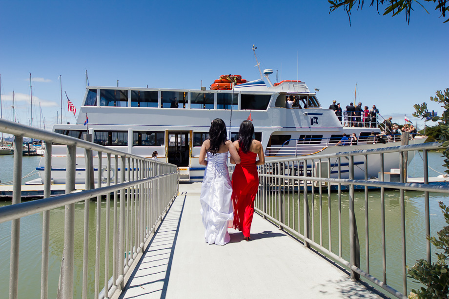 the bride and maid of honor about to board the Commodore Hornblower cruise ship for the wedding