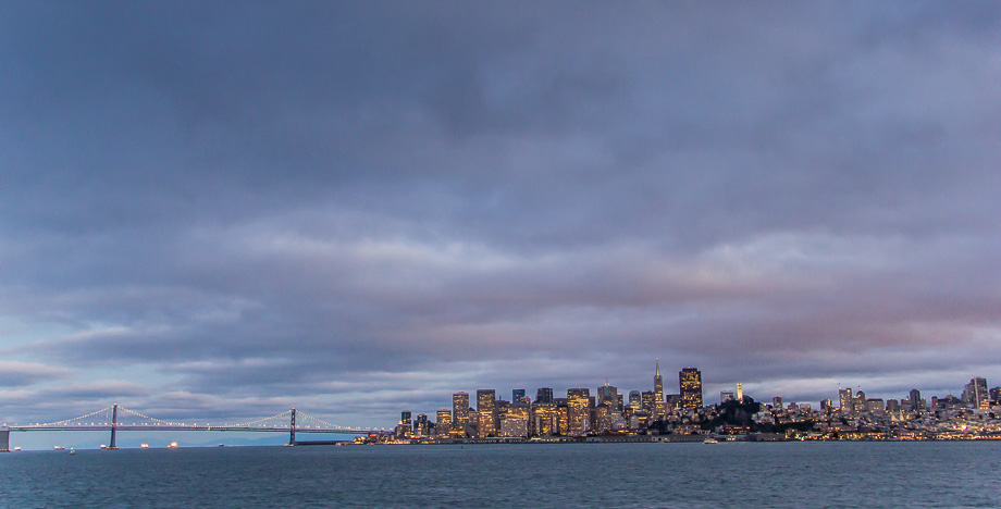 Skyline of San Francisco and the Bay Bridge as seen at dusk from aboard the California Hornblower cruise ship