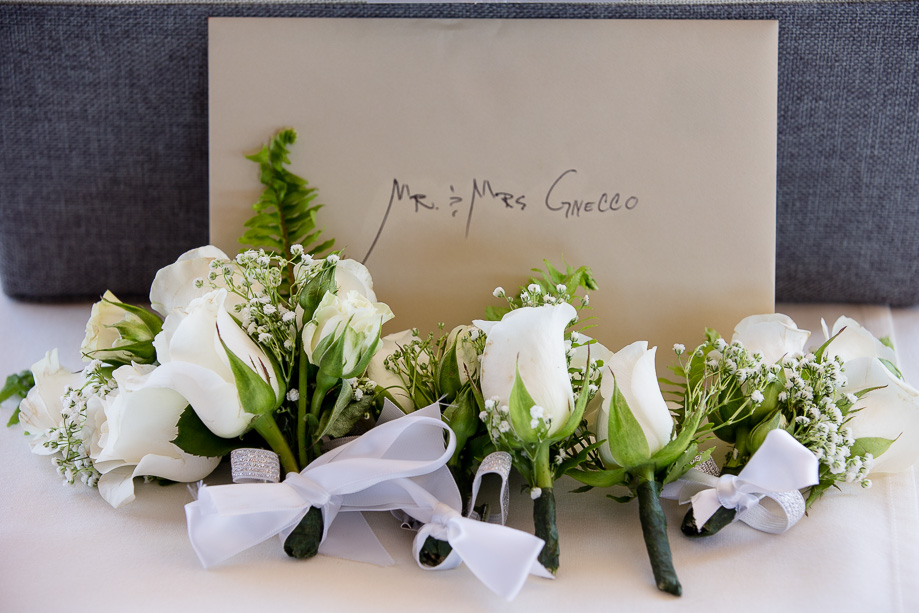 boutonnieres with a wedding card on the sign-in table