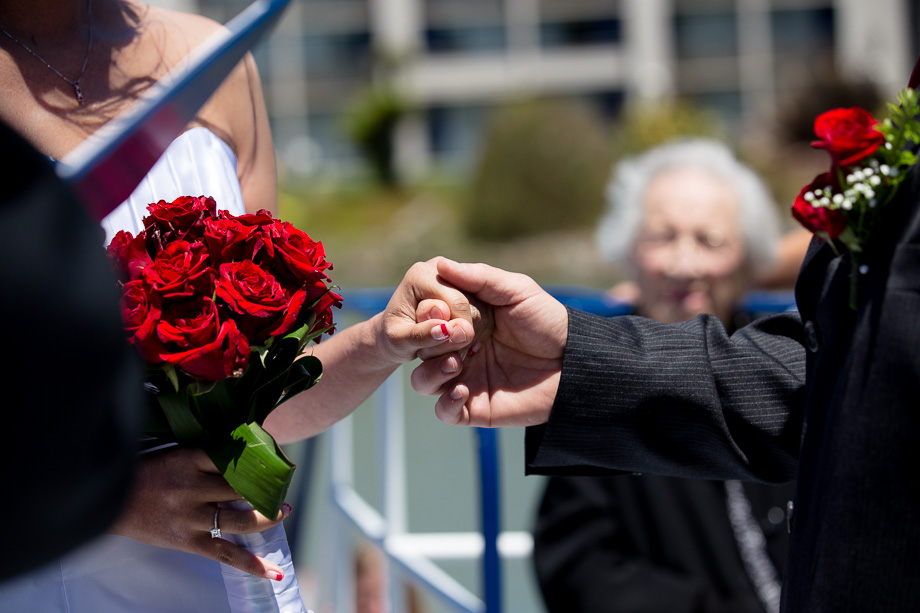 bride and groom holding hands in front of the officiant during wedding ceremony