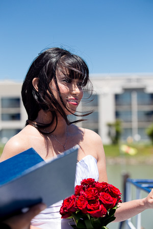 bride looking at the groom while holding a bouquet of roses