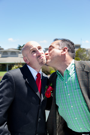 silly photo of groom being kissed on the cheek