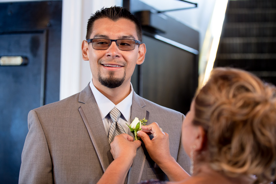 Pinning the boutonniere on the groom