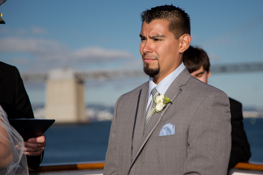 Groom looking at the bride while the captain and officiant says a few words