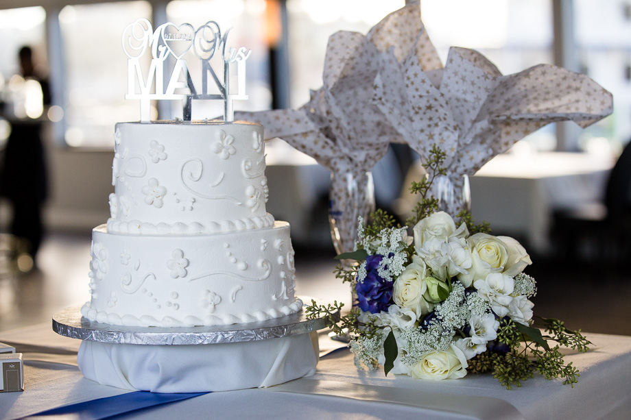 Wedding cake on table in cruise ship with bouquet next to it