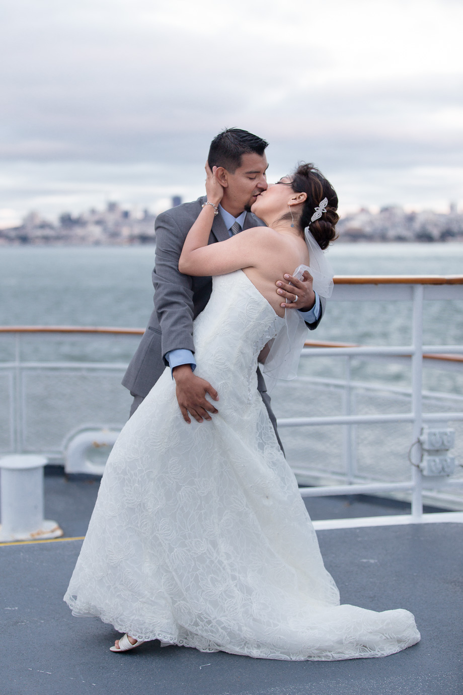 Bride and groom kissing on the deck of the California Hornblower cruise boat