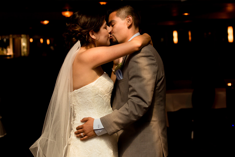 The bride and groom kissing during their first dance on the dance floor of the cruise ship