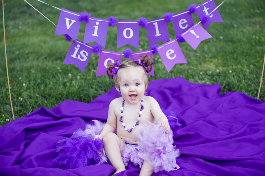 Violet the baby sitting on a purple blanket on her first birthday
