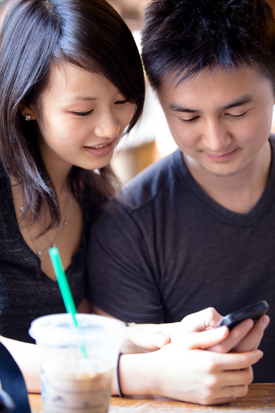 the couple at Starbucks looking at something on an iPhone