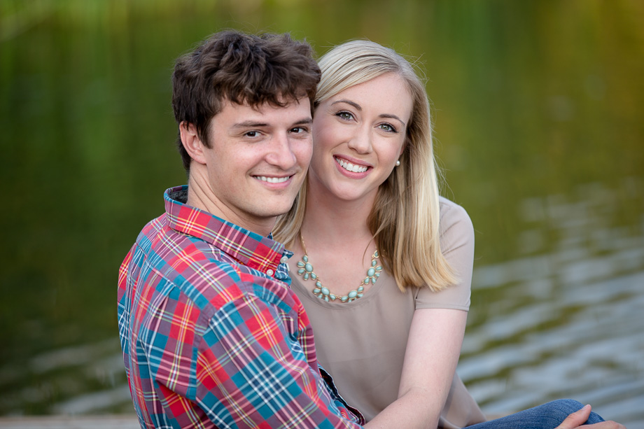 Photo of couple sitting on a dock at the lake