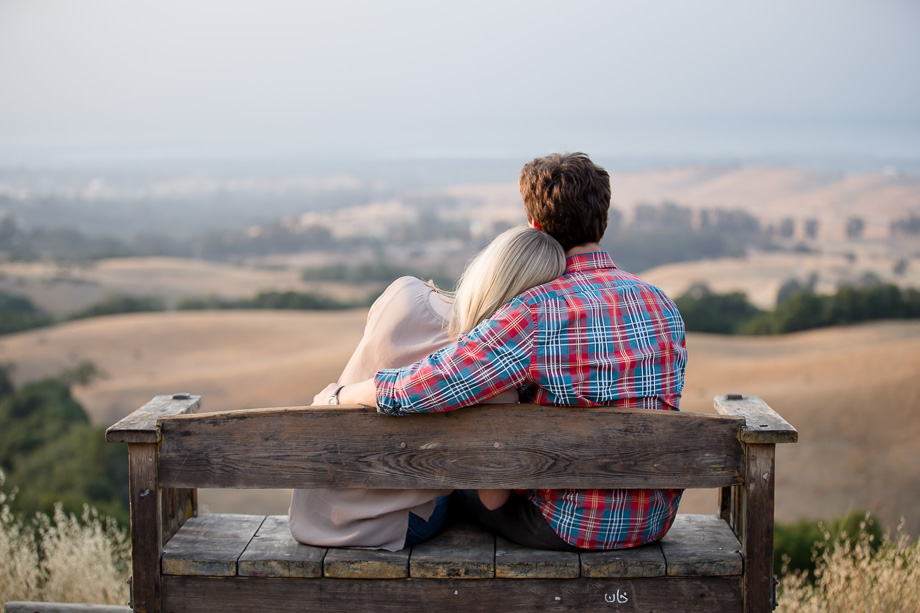 Romantic shot of newly engaged couple with her head resting on his shoulder overlooking Stanford and Palo Alto from Foothills Park
