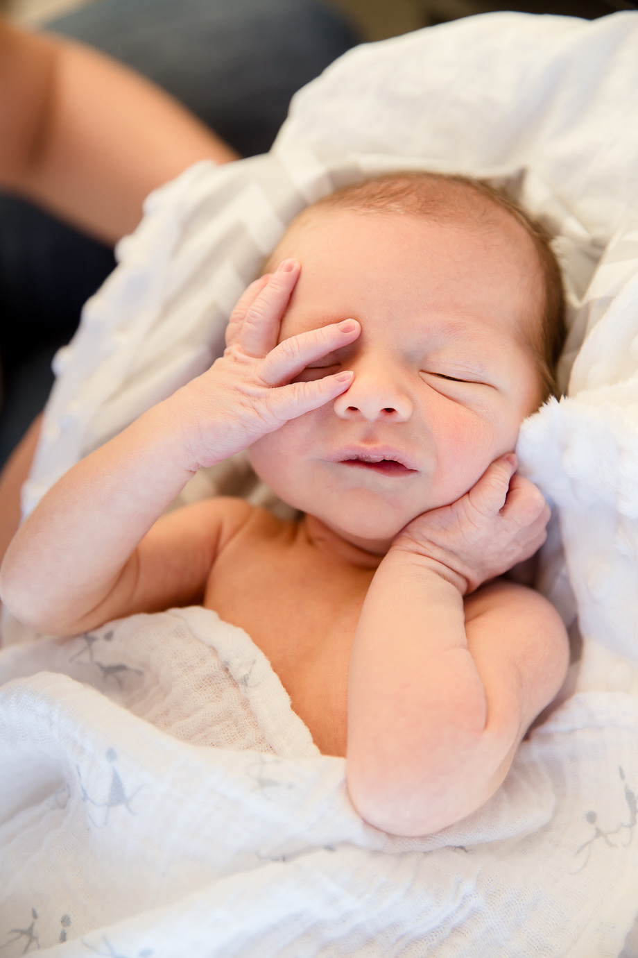 sleepy infant baby rubbing his eyes