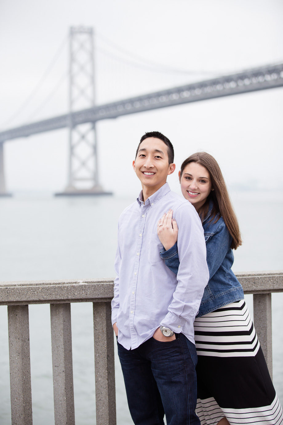 The newly engaged couple in front of the Bay bridge
