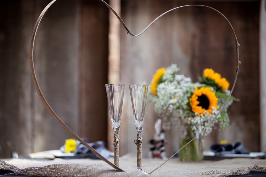 Two champagne glasses, flowers, and heart outline on sweetheart table