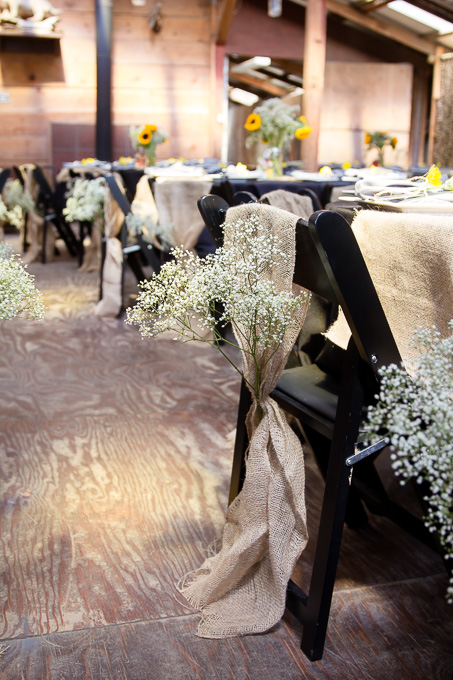 Delicate small flowers on the backs of chairs at wedding reception