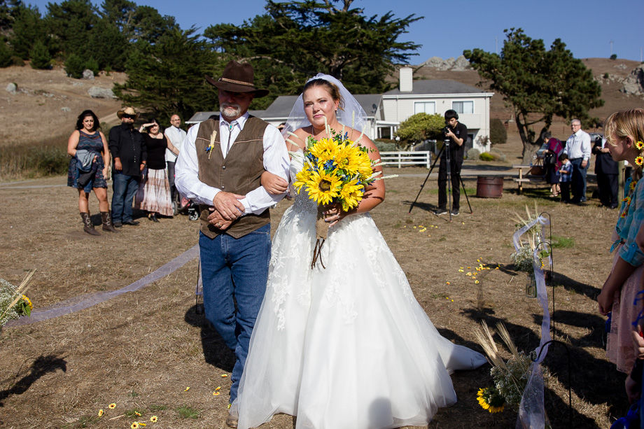 Bride and father walking down the aisle with sunflowers at Chanslor Ranch