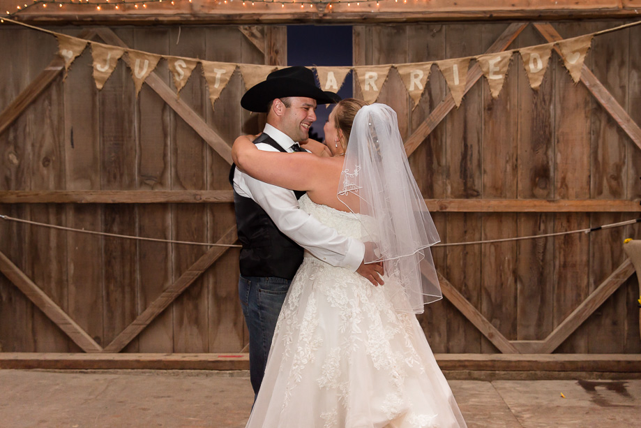 Bride and groom during first dance indoors in their barn wedding