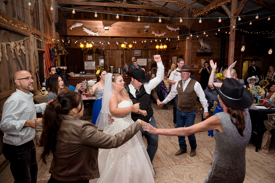 Bride and groom dancing with guests around them in the barn at Chanslor Ranch