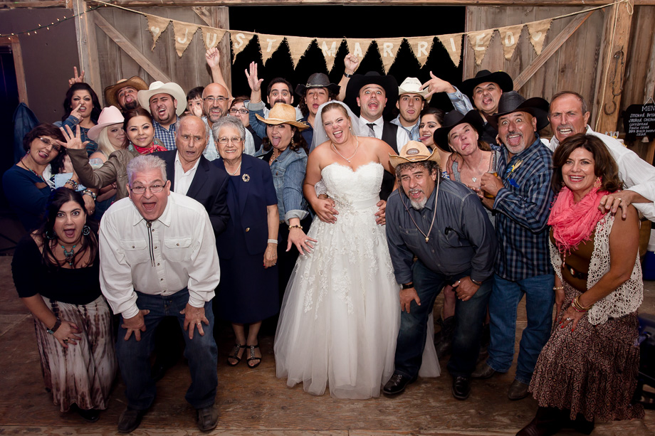 Group shot of everyone at the wedding reception in front of the Chanslor Ranch barn door