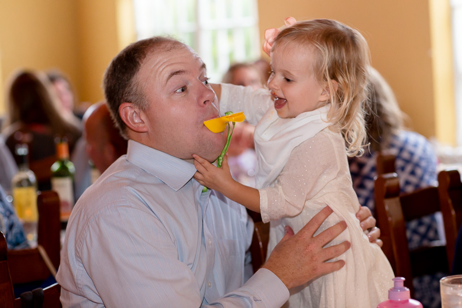 Happy little girl playing with Dad during the wedding reception at the Mezzaluna restaurant