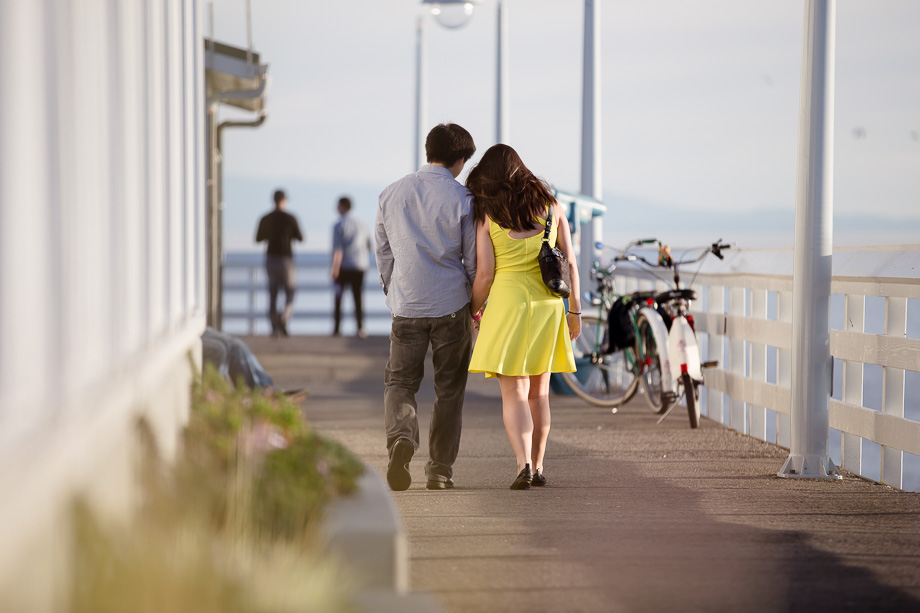 Christian and Daena walking towards the end of the pier at Santa Cruz Municipal Wharf to propose!