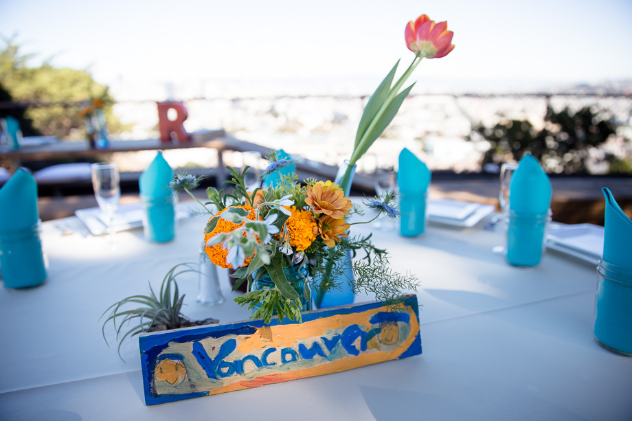 Gorgeous blue and yellow floral centerpiece with blue napkins, hand painted wooden table sign