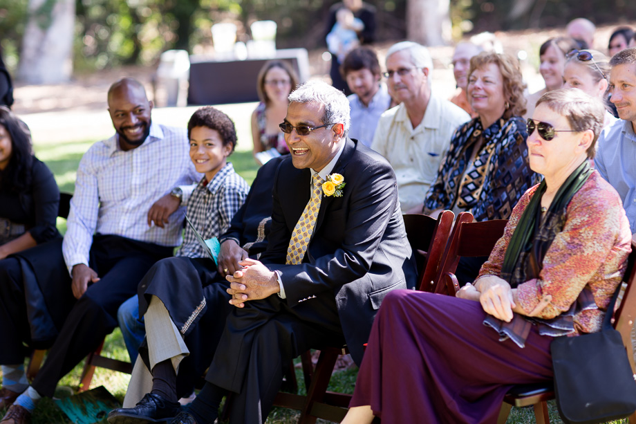 Family and guests laughing during wedding ceremony