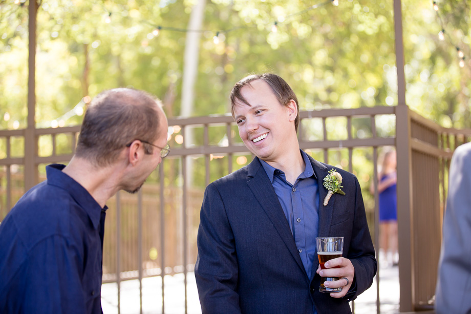 Groom chatting with his friends during cocktail hour