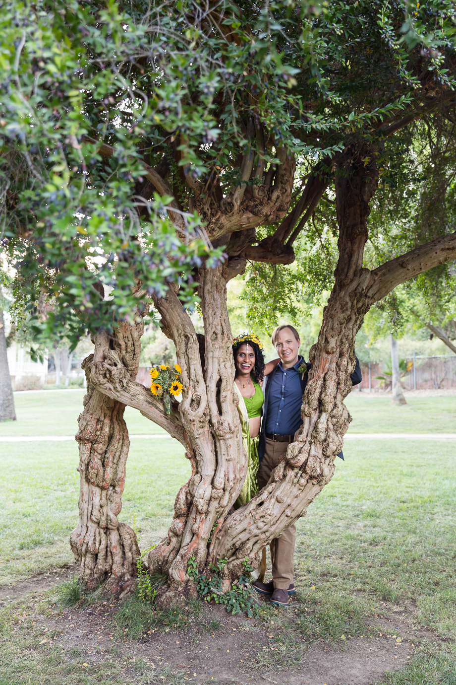 Photo of the happy couple behind a tree at the New Alamaden Quicksilver Mining Museum