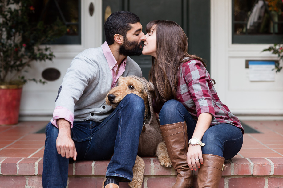 couple about to kiss while dog rests head on dads lap