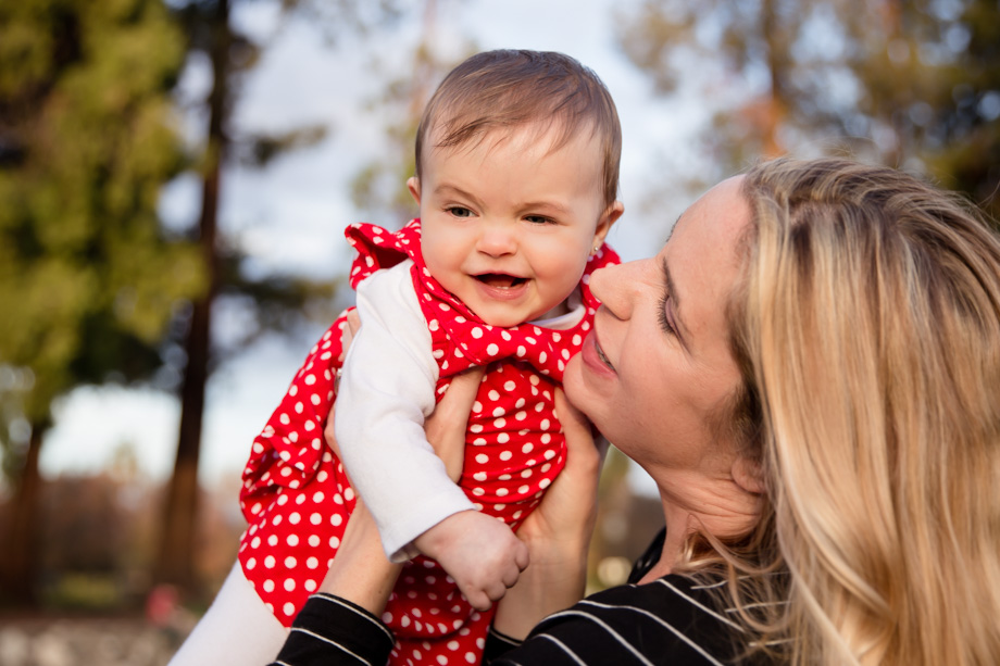 Xmas family photo - happy baby girl in her red polka dot dress