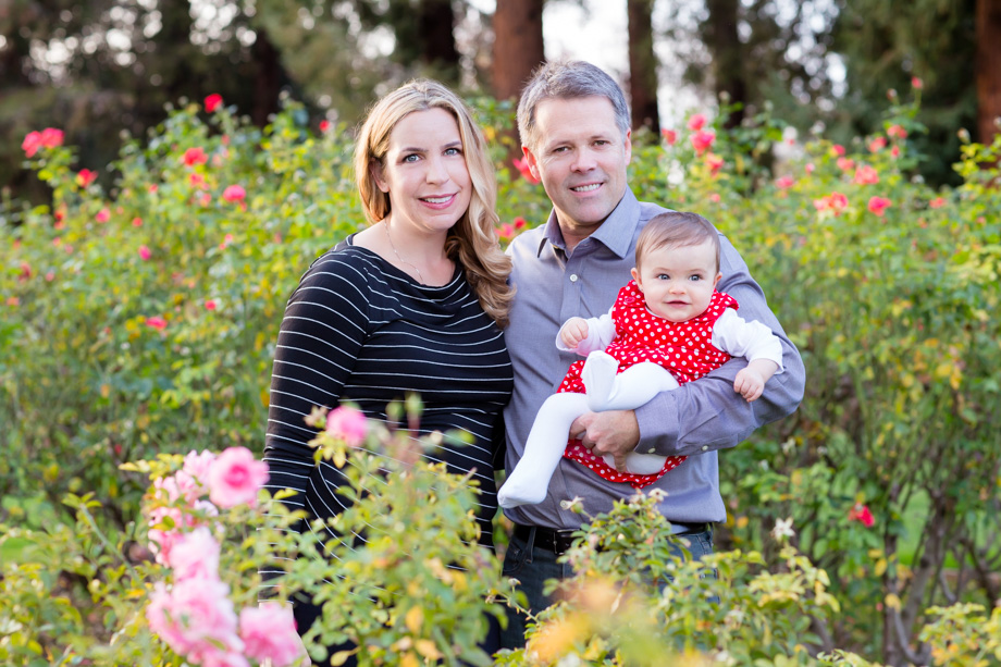 A beautiful family surrounded by pink rose bushes just before Christmas