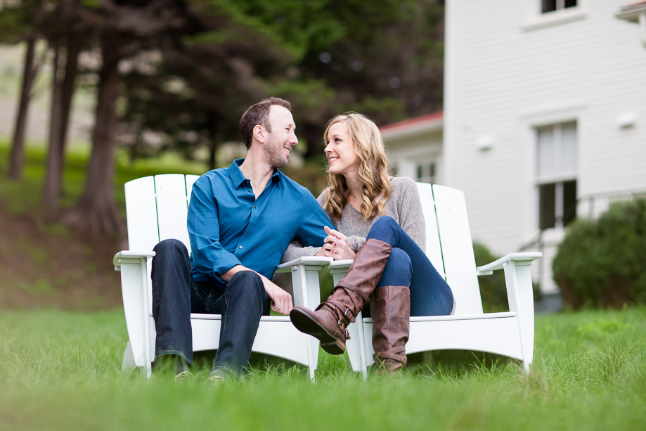 couple looking into each others eyes on white wooden lawn chairs