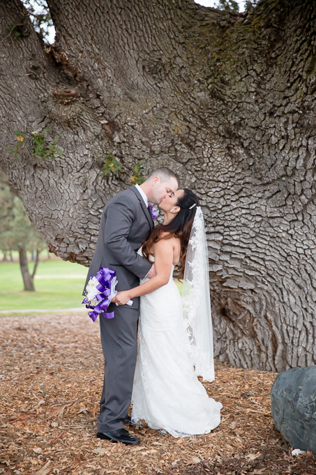 Beautiful couple kissing under the giant oak tree