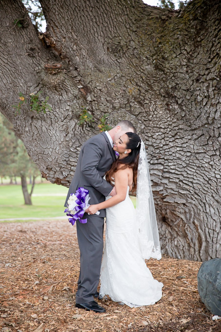 Beautiful couple kissing under the giant oak tree
