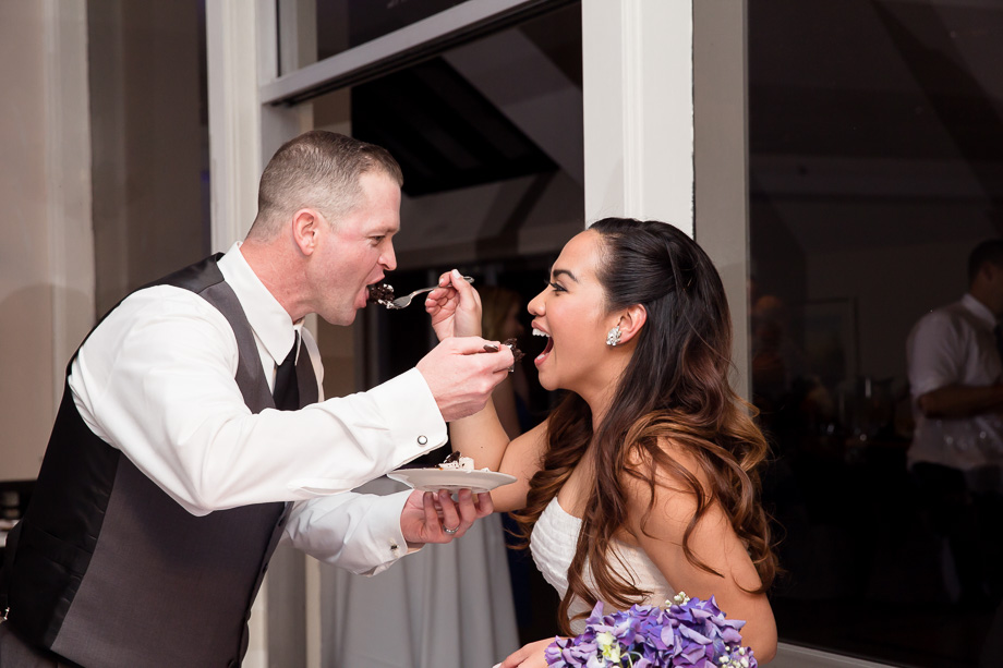 Bride and groom feeding each other cake at Boundary Oak Golf Club