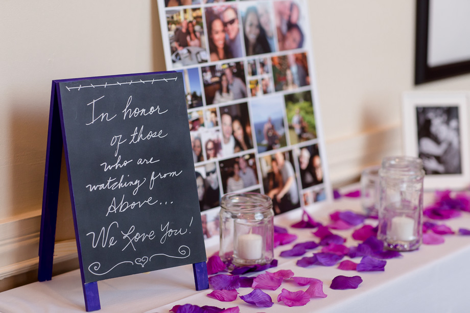 wedding sign-in table with candle jars and violet flower petals