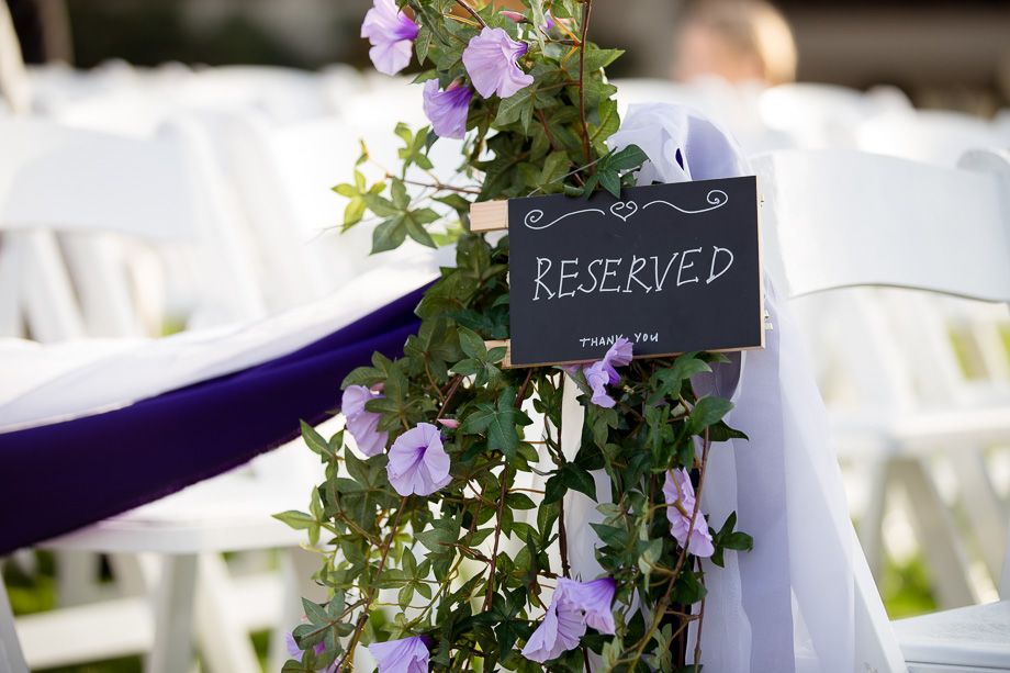 Reserve seat sign at the wedding ceremony with purple petunia