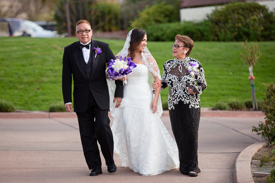 Bride making her entrance with her parents escorting her at the Boundary Oak Golf Club