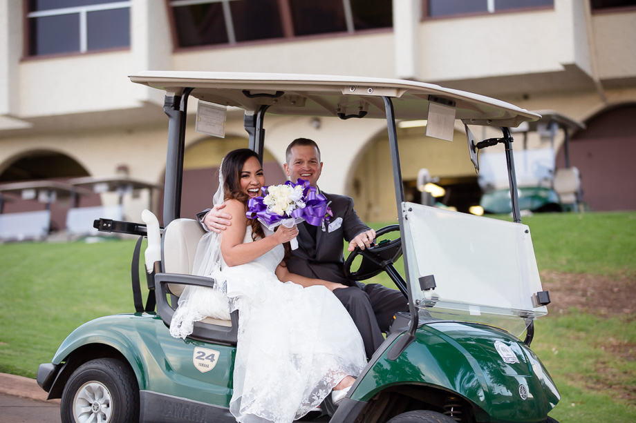Happy newlyweds driving a golf cart at the Boundary Oak Golf Club