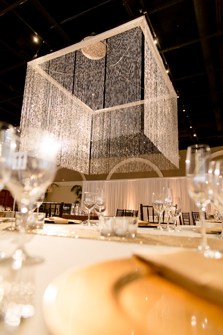 glamrous wedding reception site setup at Casa Real - golden plates with a grand hanging chanelier