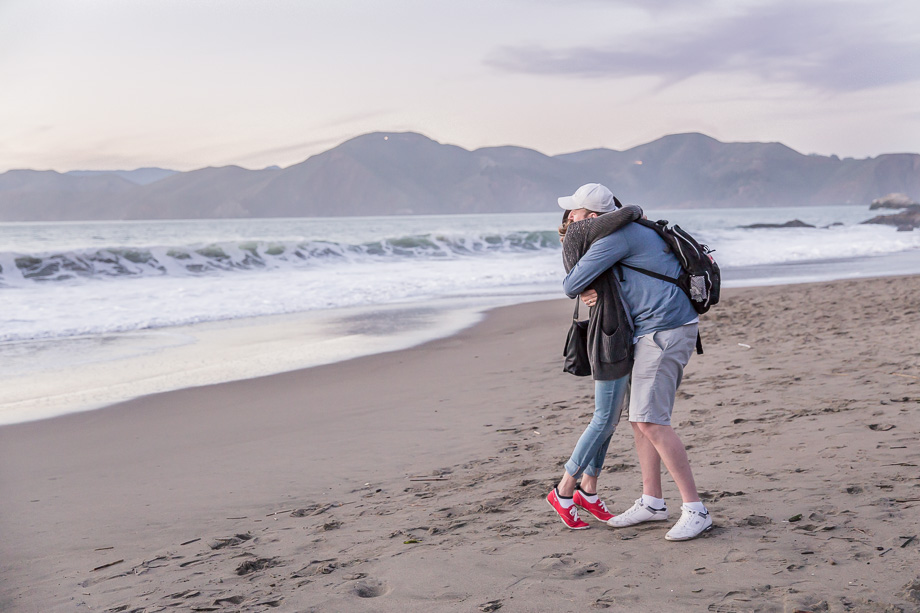 happy couple after surprise proposal at baker beach san francisco during sunset - bay area engagement photographer