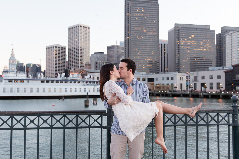 romantic san francisco engagement photo at pier with skyline backdrop