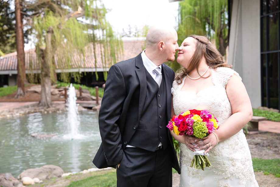 wedding day portrait with bouquet in front of fountain