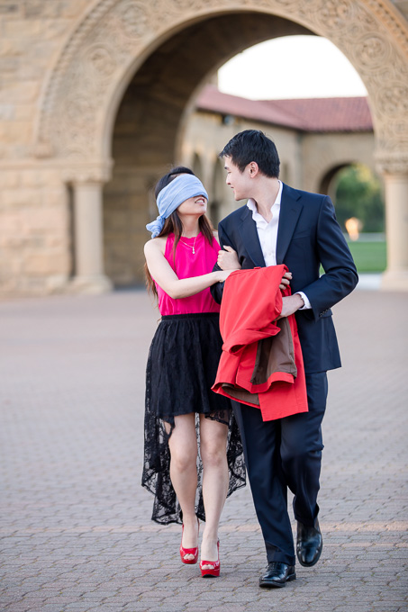 Rudy leading Sophie into Stanford main quad blindfolded for her surprise engagement proposal